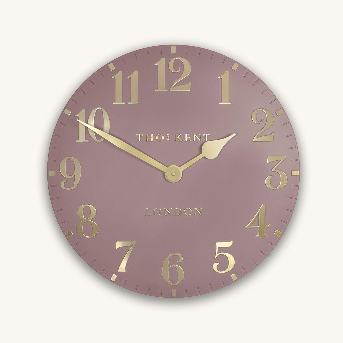 Round pink wall clock with gold numbers and 'Thomas Kent' branding on a light pink background