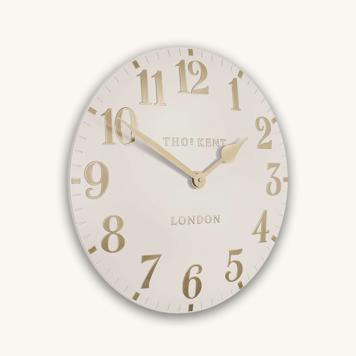 Cream wall clock with gold numbers and 'Thomas Kent London' text on a white background