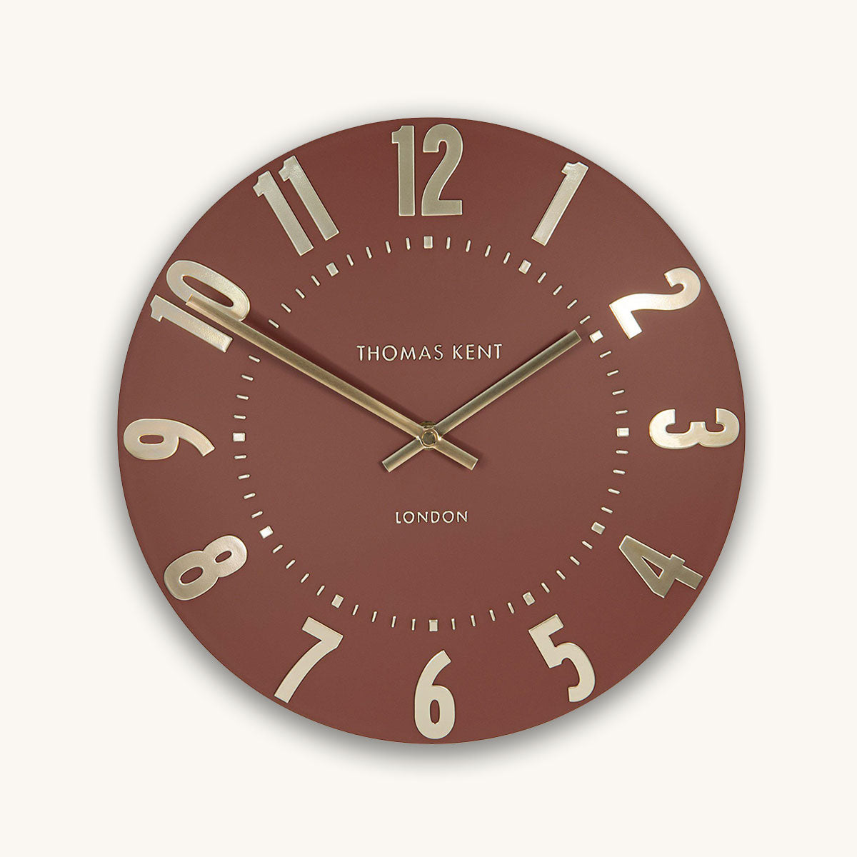 Round wall clock with red face and gold accents on a white background