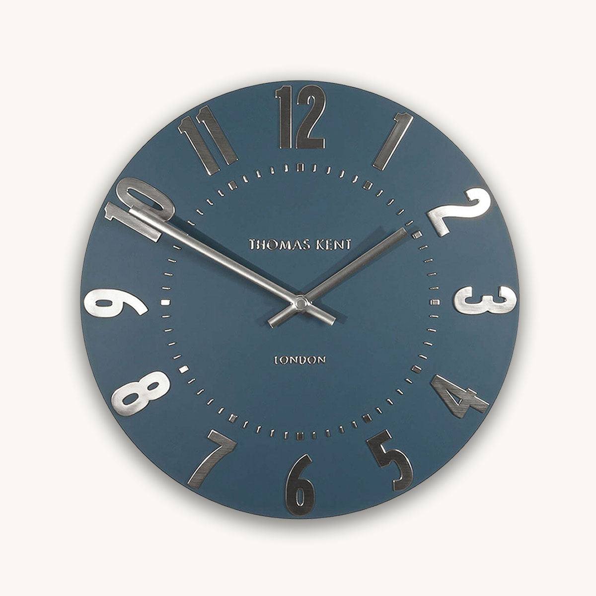 Blue wall clock with silver accents on a white background