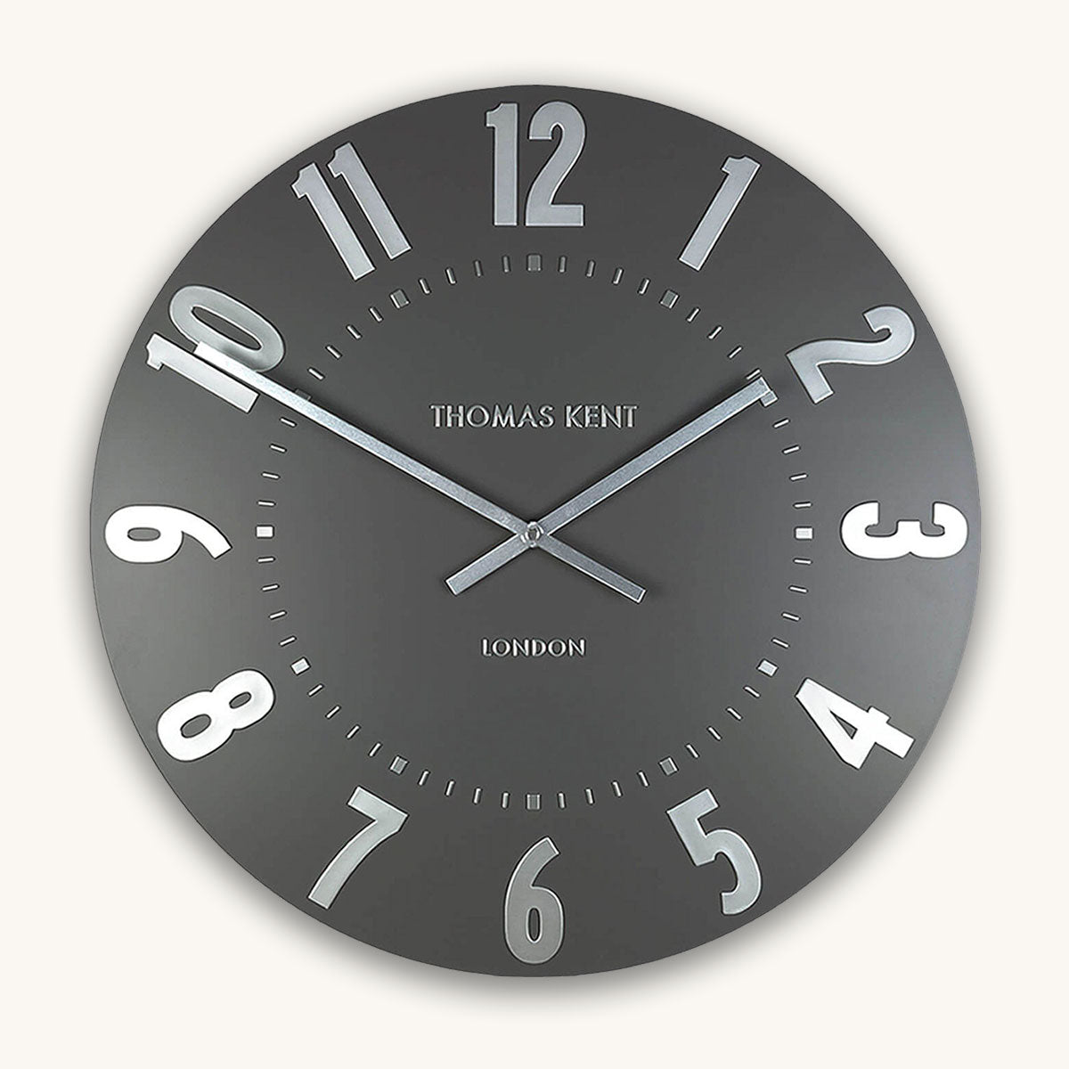 Gray wall clock with white numbers and 'Thomas Kent London' branding on a white background