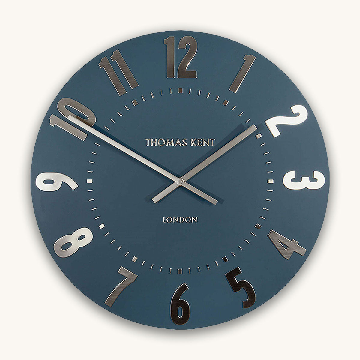 Blue wall clock with silver numerals on a white background