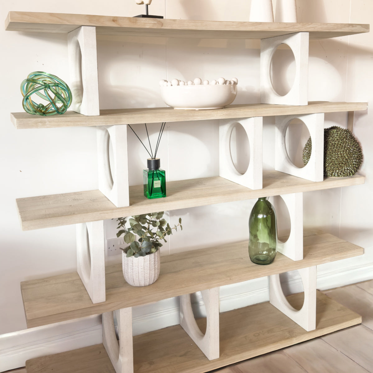 Wooden shelf with decorative items against a white wall