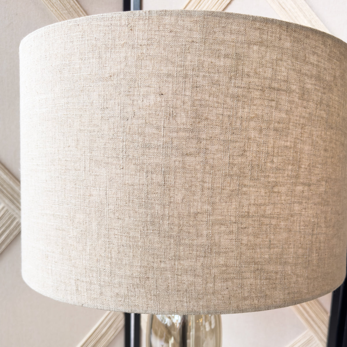 Close-up of a textured beige lampshade against a neutral background