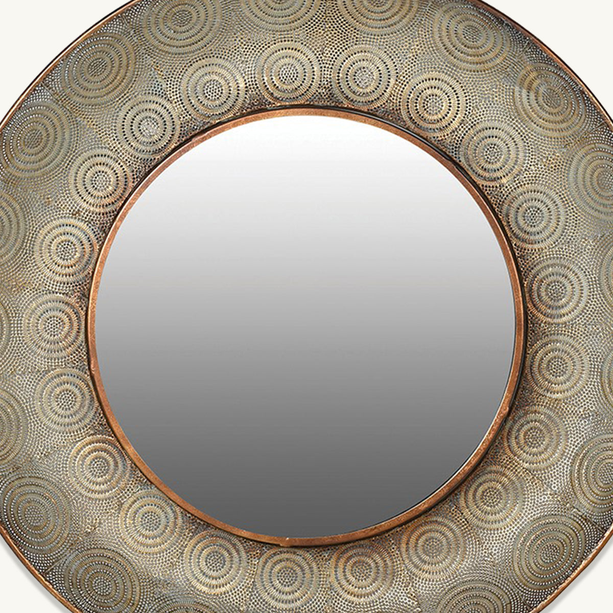 A close up of an aged gold round filigree mirror with a central bright gold border on the frame.