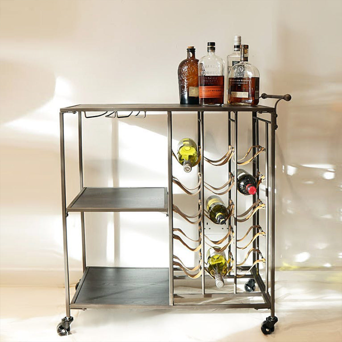 A black metal and leather bar trolley with wine bottles and glasses stored on it, set against a white background.