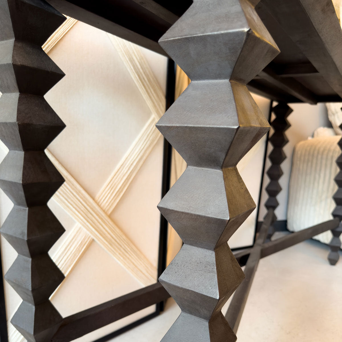 Close-up of a geometric leg console table made with black wood