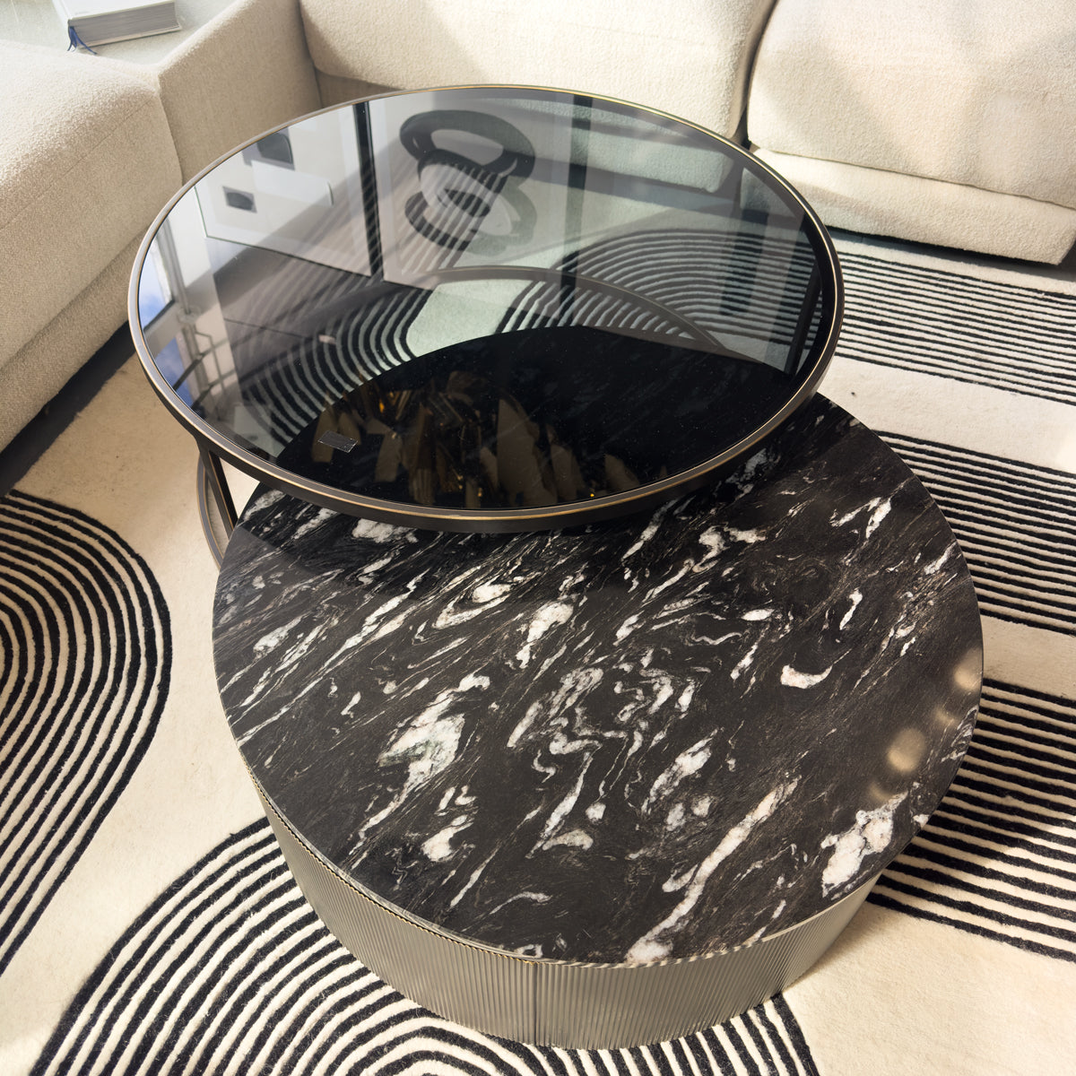 Round marble coffee table with glass top on a patterned rug