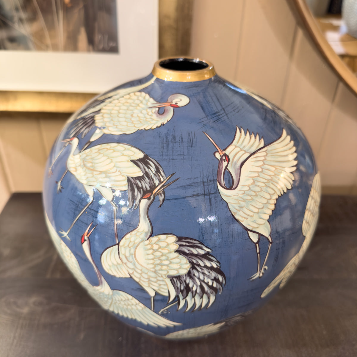 Decorative vase with crane designs on a blue background
