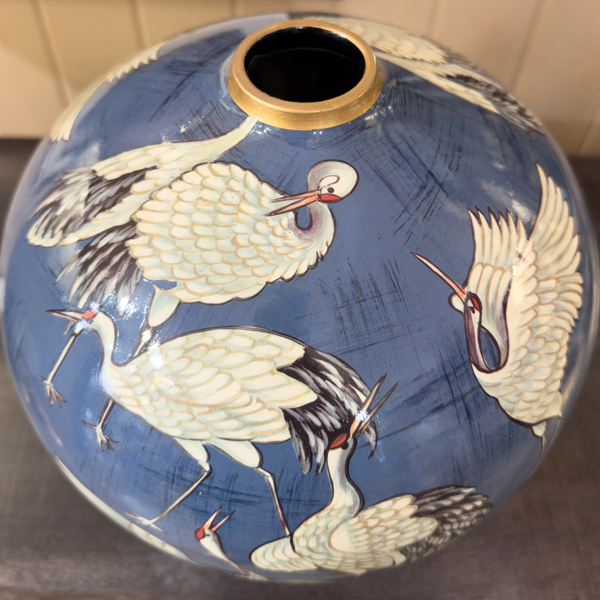 Decorative vase with crane designs on a blue background