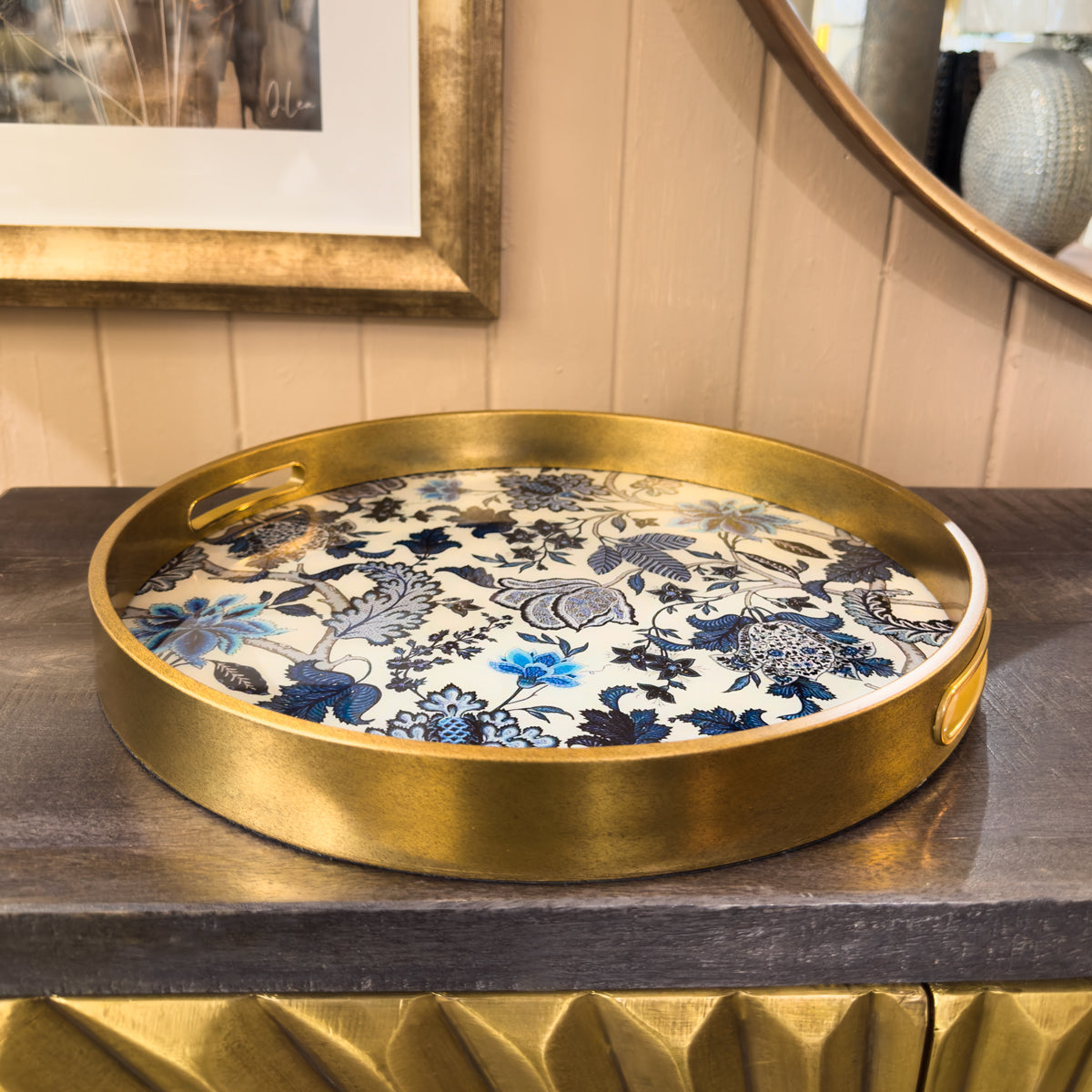 Gold tray with floral design on a wooden surface
