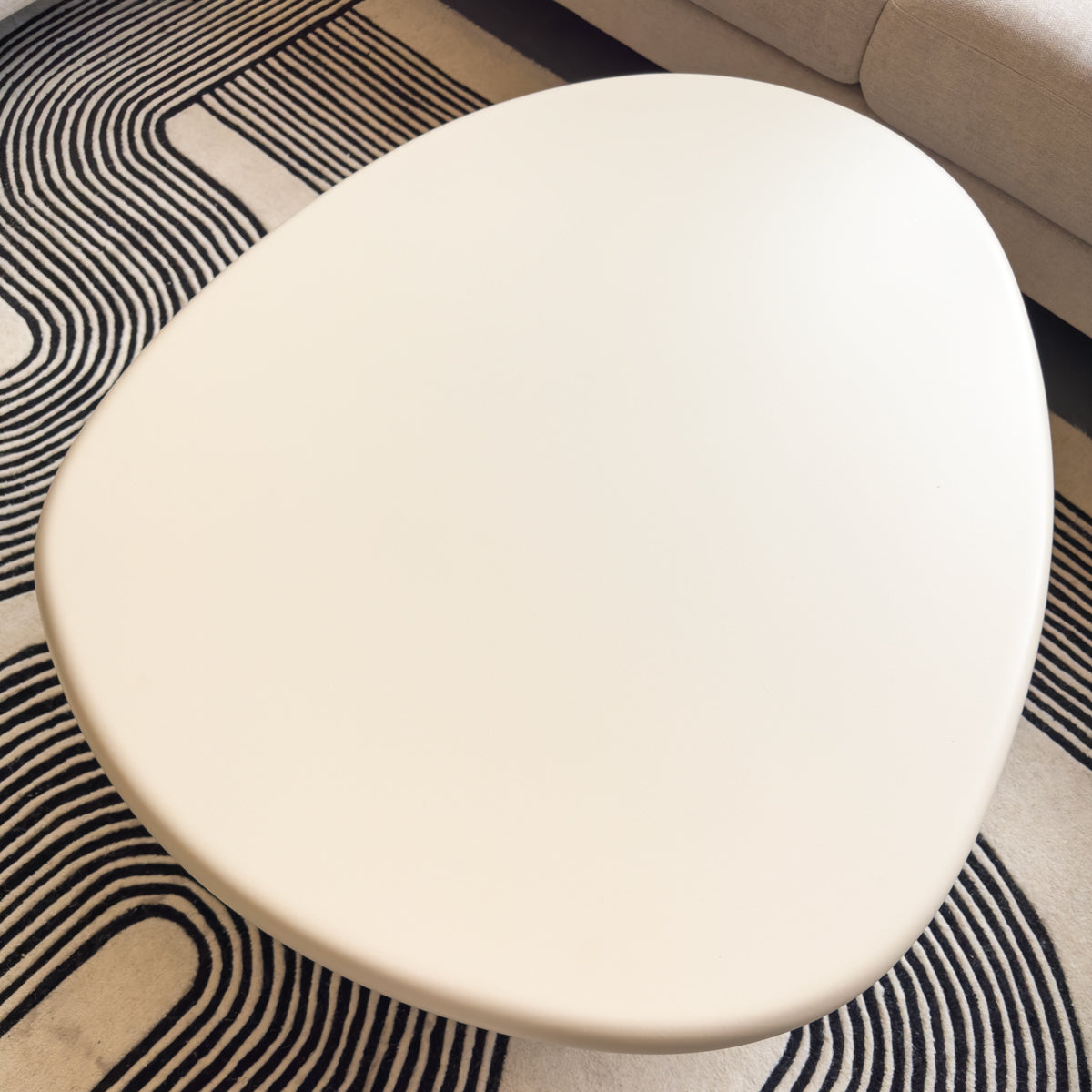 Organic shape white table on a patterned rug