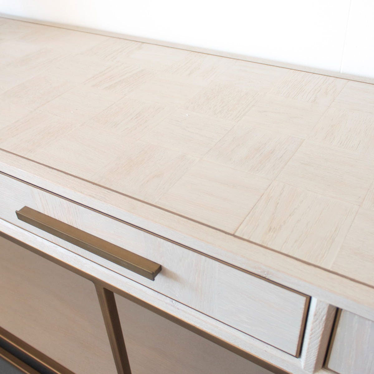 Close-up of a console table wooden drawer with a metallic handle on a white background