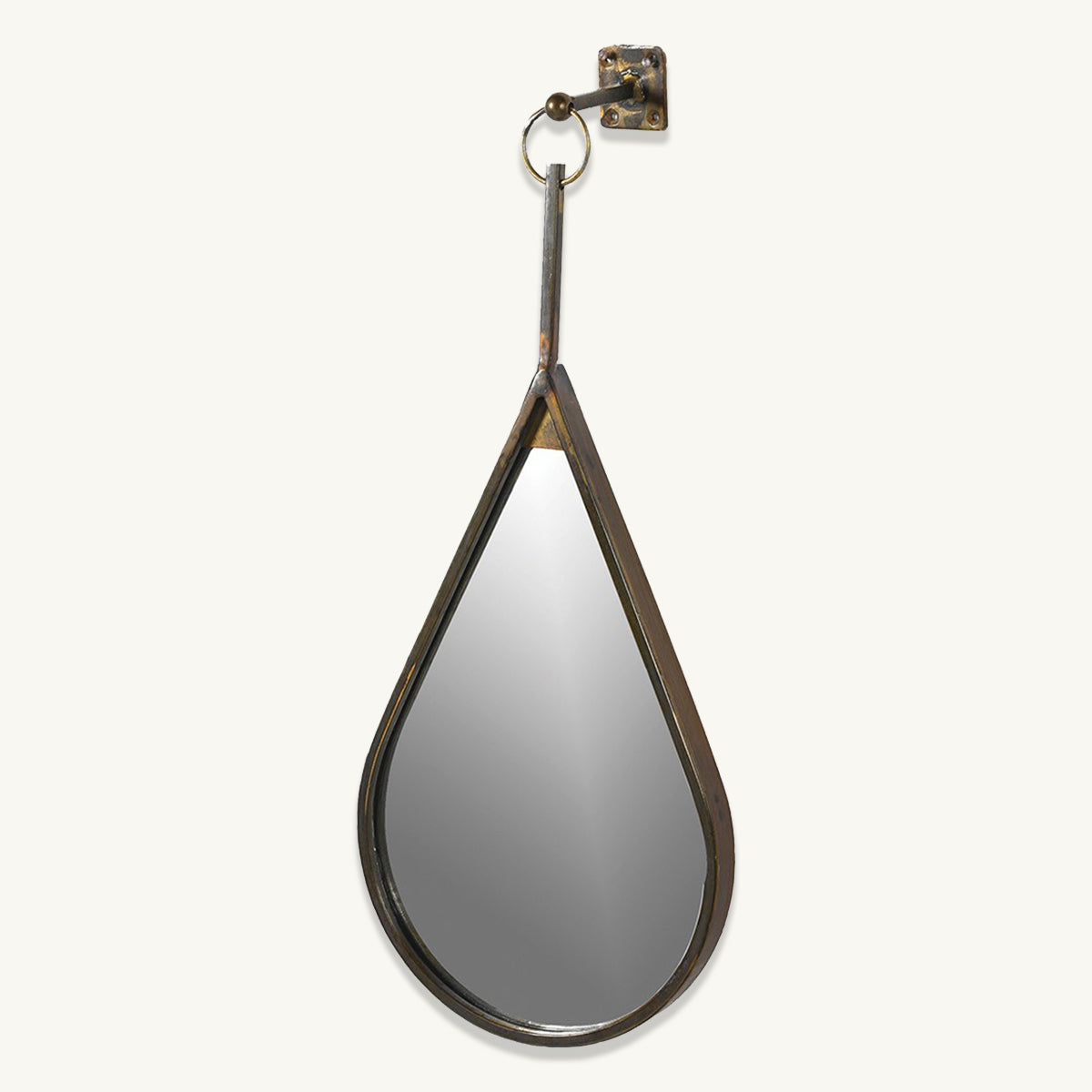 An antique gold teardrop shaped mirror which hangs from a hoop on a wall bracket.