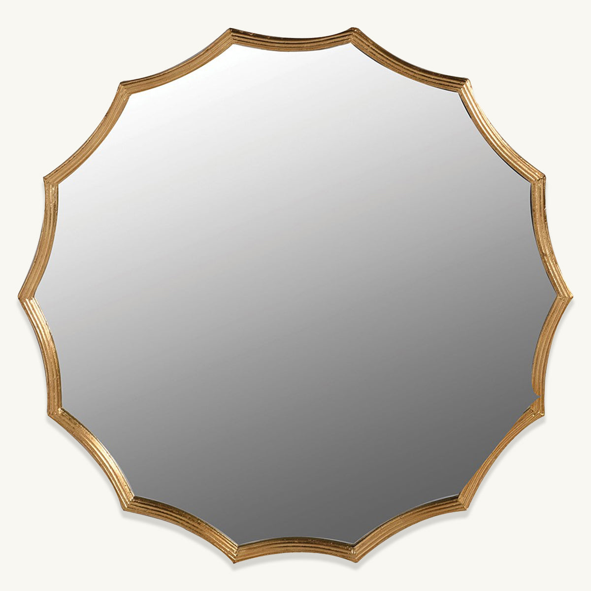 A gold round mirror with unique scalloped edging around the frame.