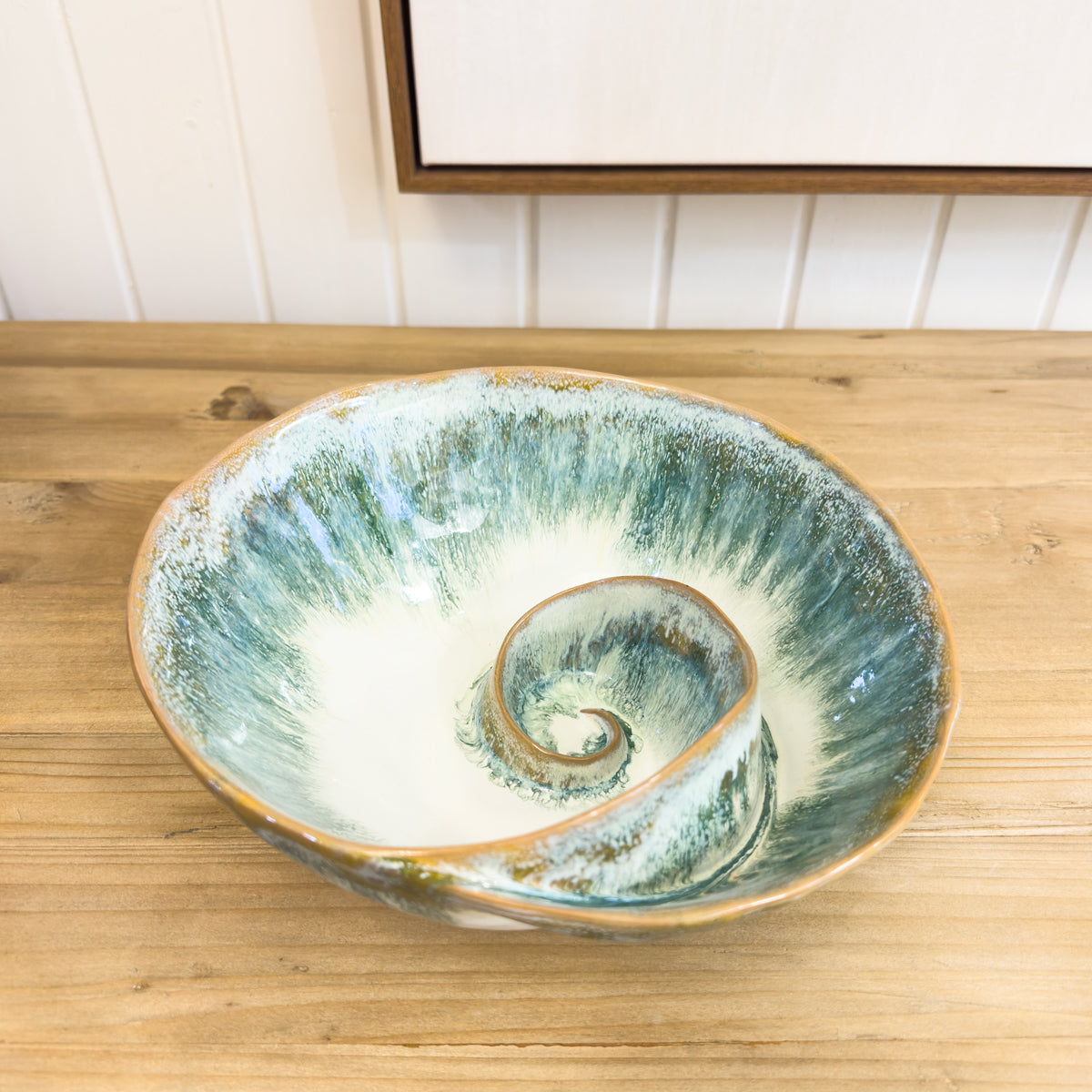 Ceramic bowl with a spiral design on a wooden surface