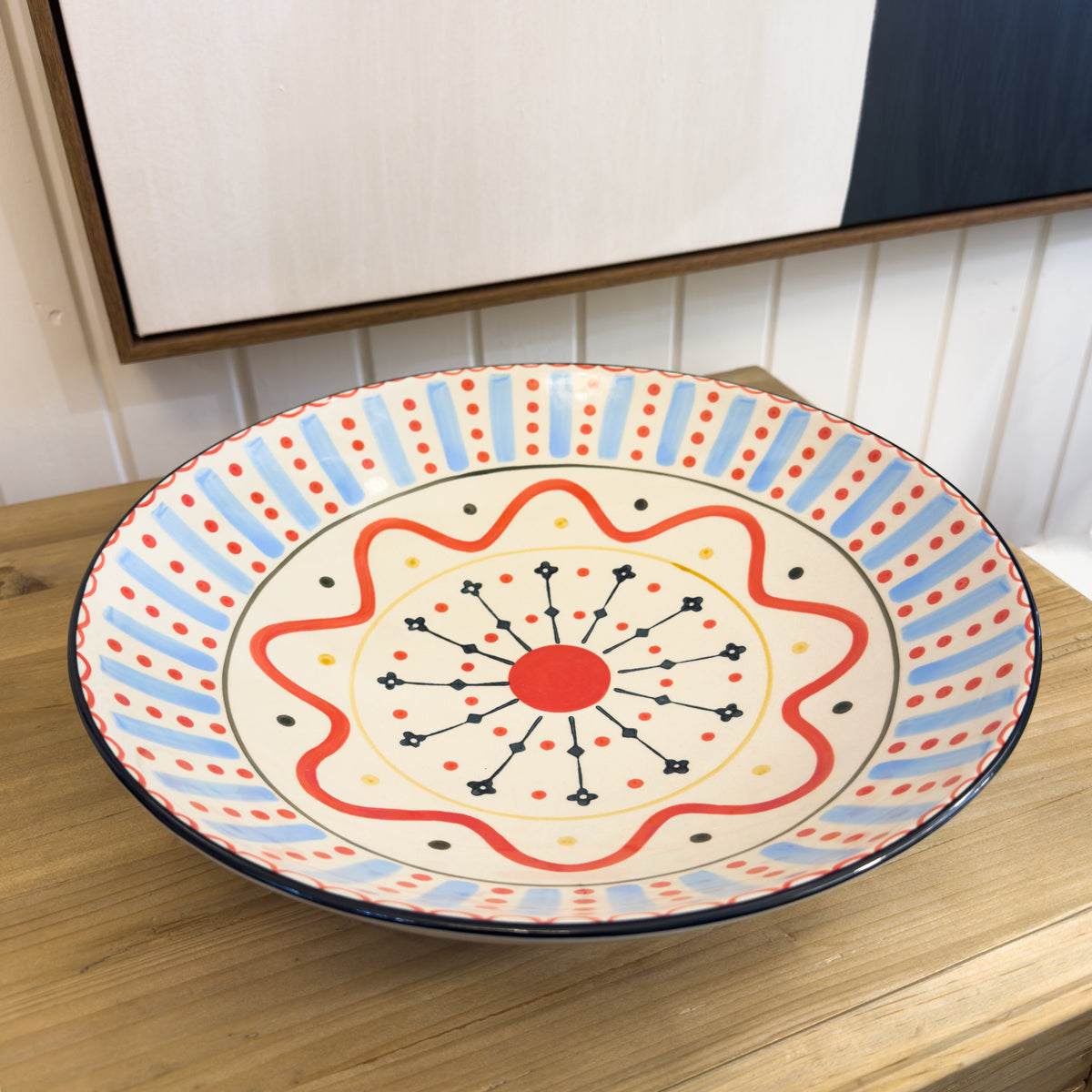 Decorative ceramic plate with colorful patterns on a wooden surface.
