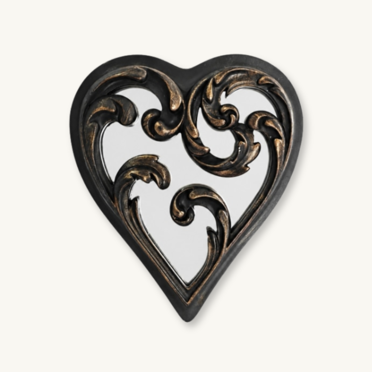 Ornate black-and-bronze metal heart mirror with curling scrollwork cutouts, centered on white, evoking a romantic vintage mood.