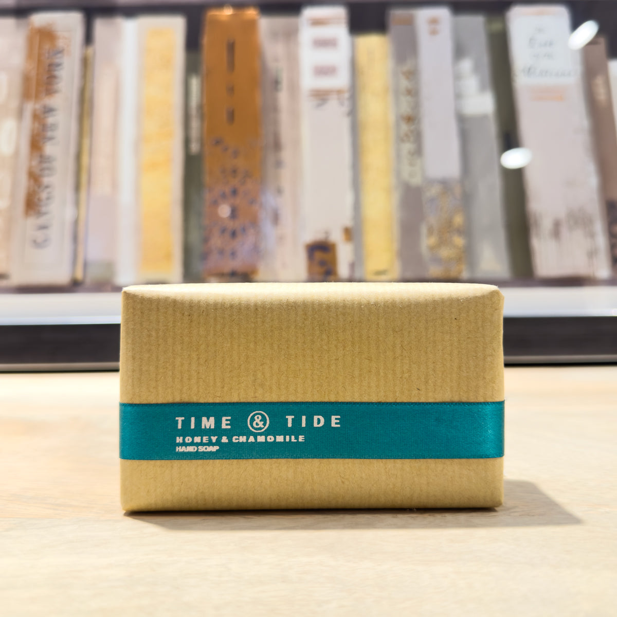 Beige honey soap bar with a blue band labeled 'Time & Tide' on a wooden surface.