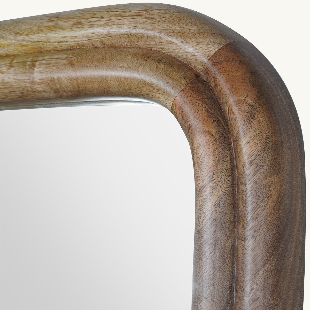 A close up of a ridged mango wood frame mirror with curved edges.