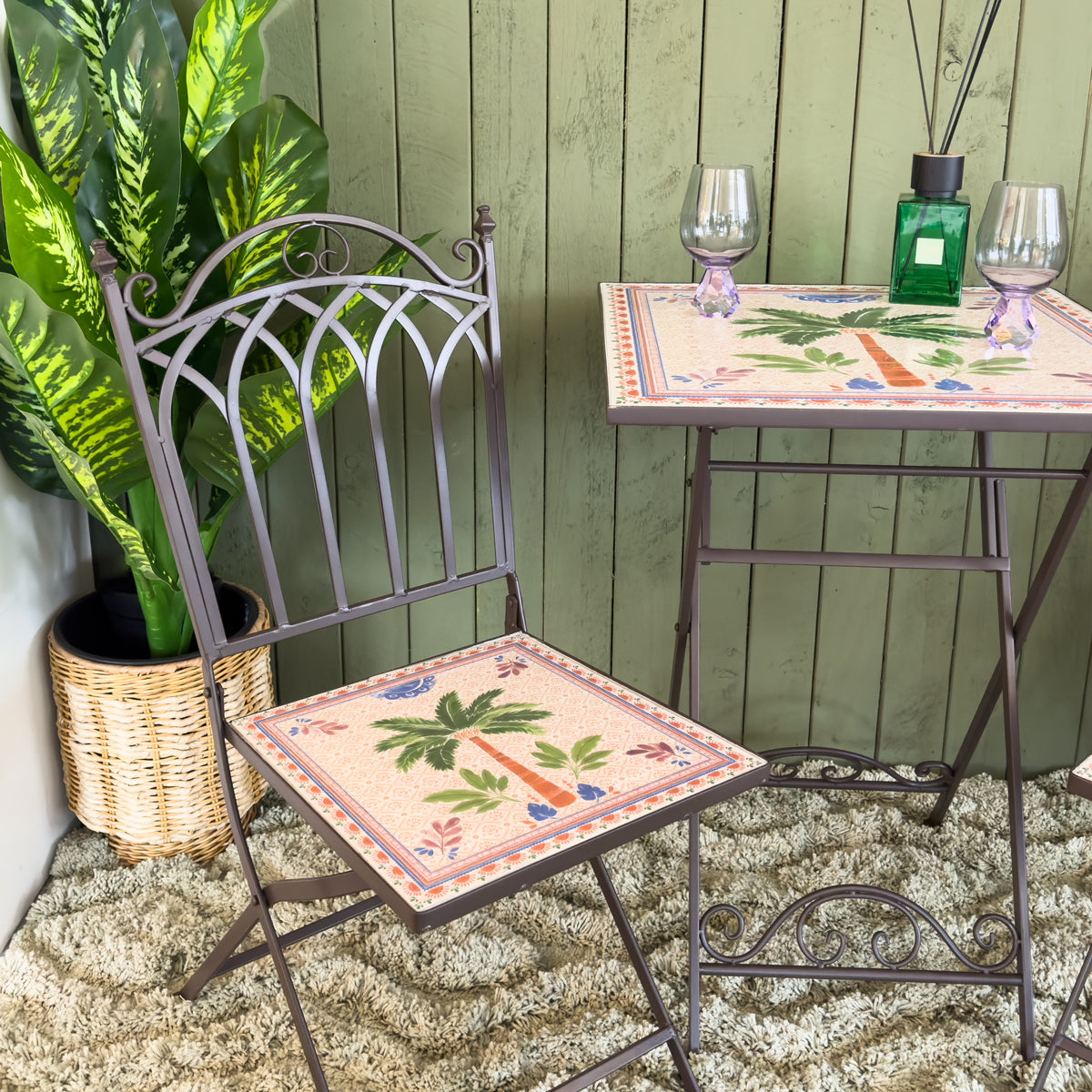 Metal bistro chair and table set with decorative tablecloth in a garden setting