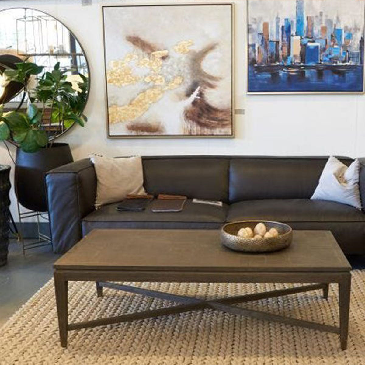 Living room with a dark gray sectional sofa, wooden coffee table, and wall art.