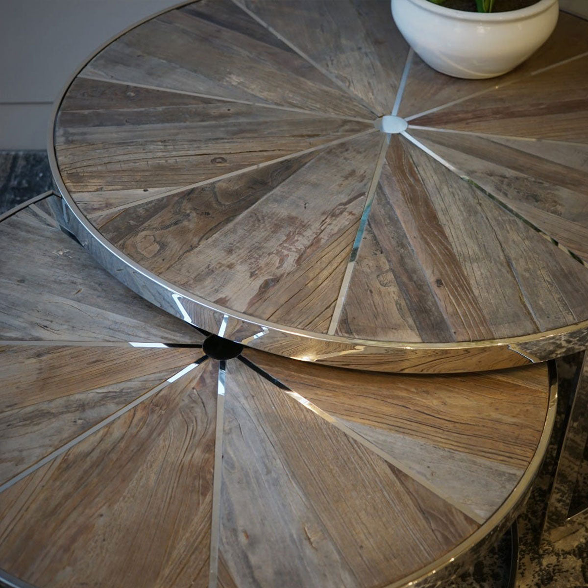 Round wooden table with metal inlay top on a blue distressed rug