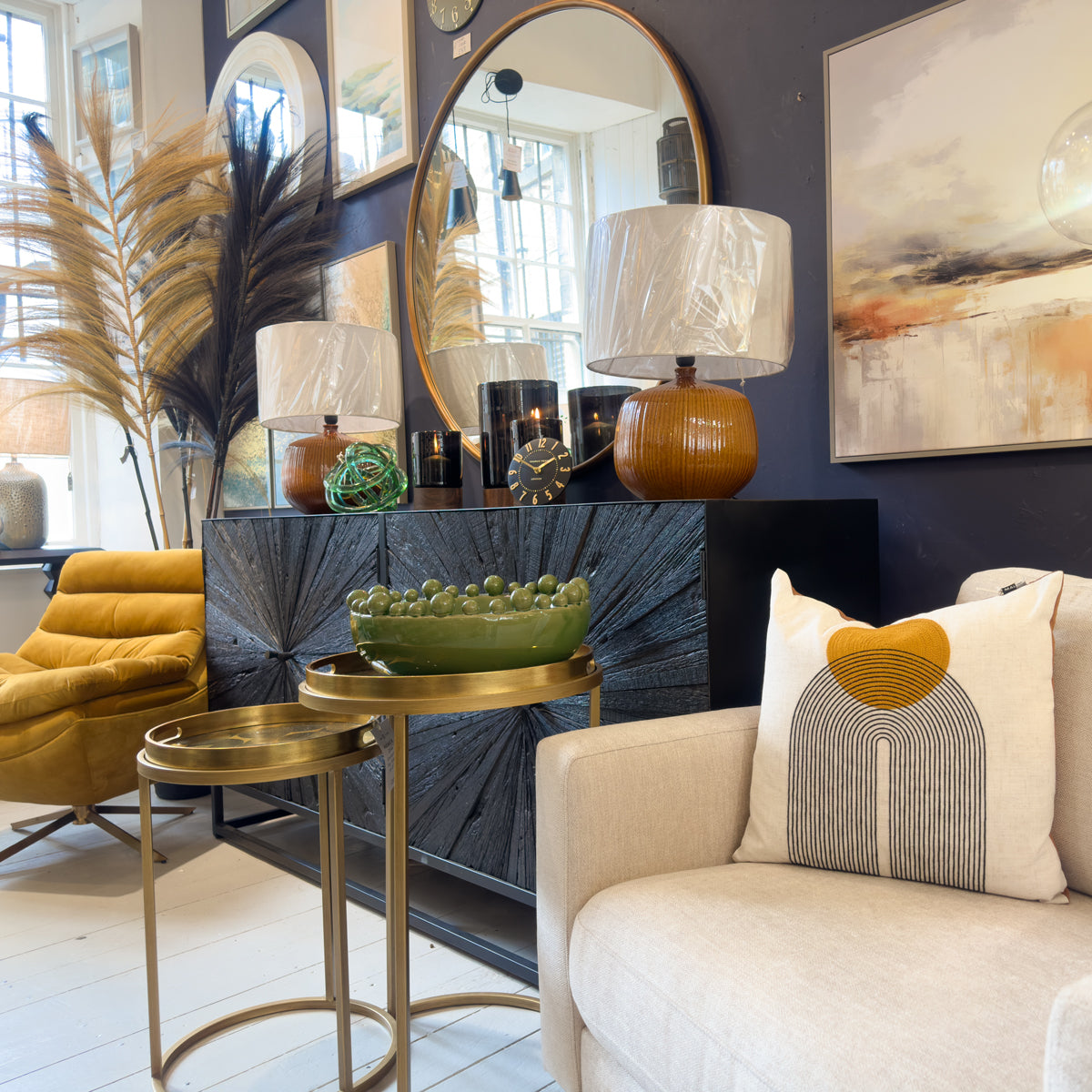 A black sideboard with mustard and olive green decorative items