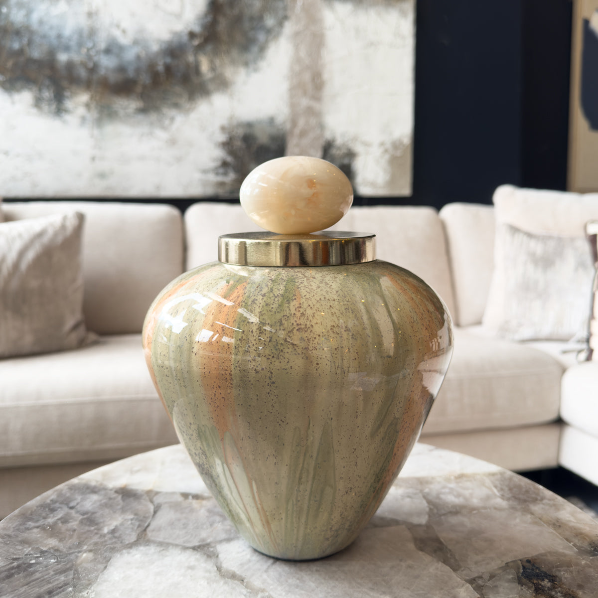 Decorative vase with a marble-like finish on a coffee table in a living room setting.