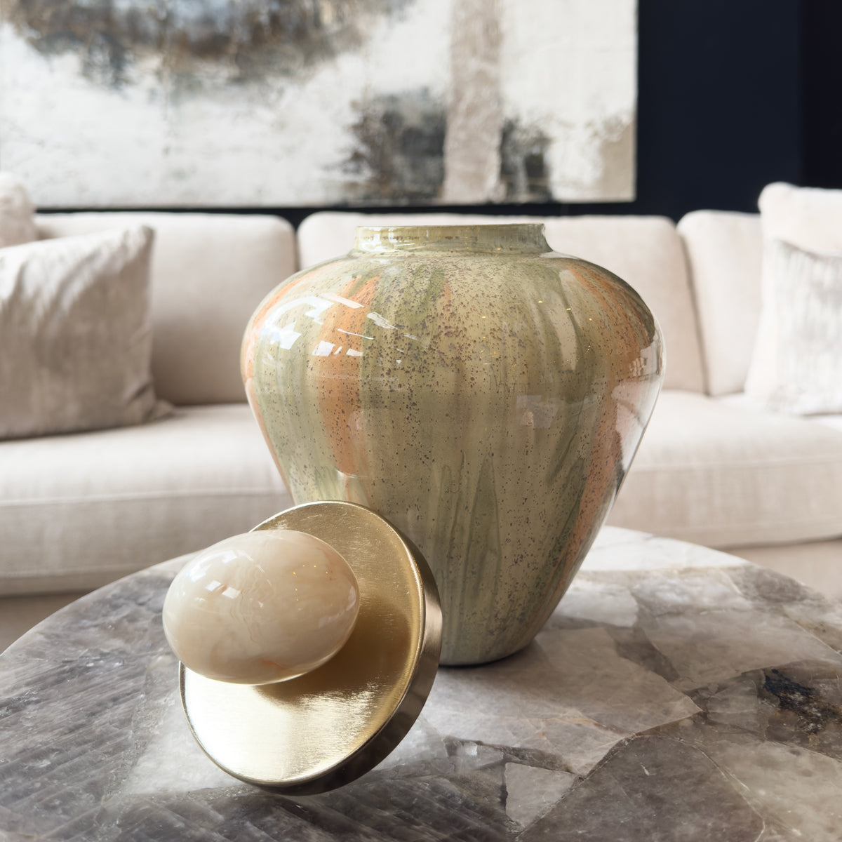 Decorative urn with a lid on a marble surface in a living room setting