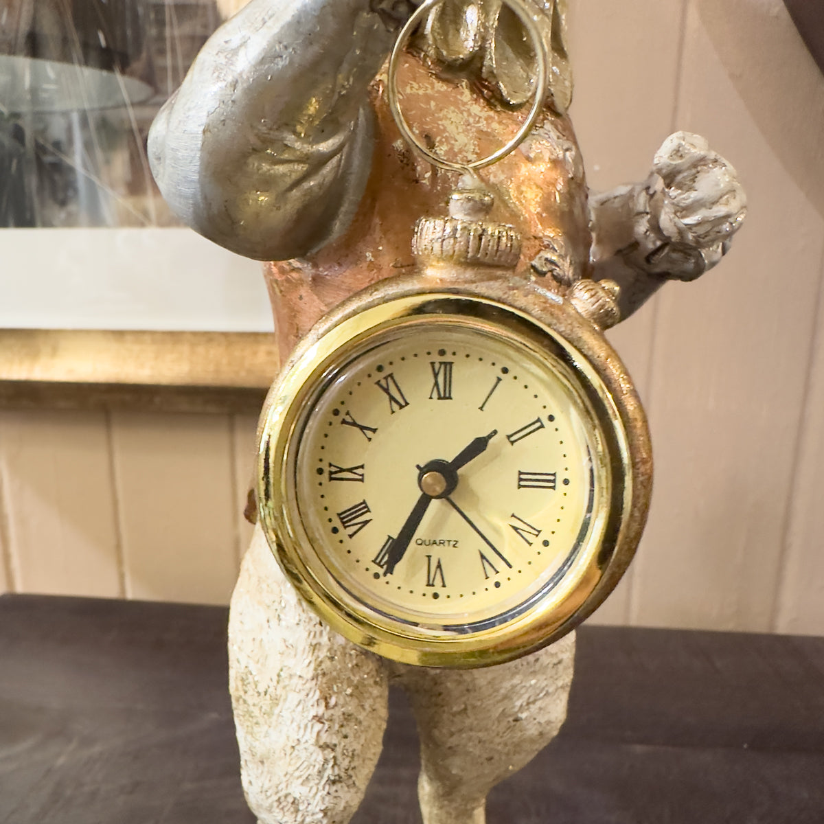 Decorative clock with Roman numeral face on a rabbit base