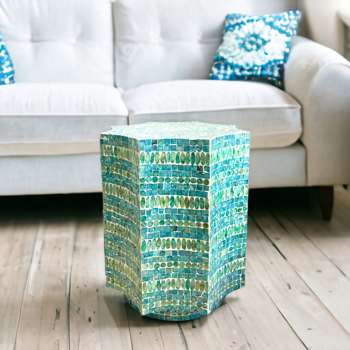 Hexagonal mosaic side table with blue and green tiles in a living room setting.
