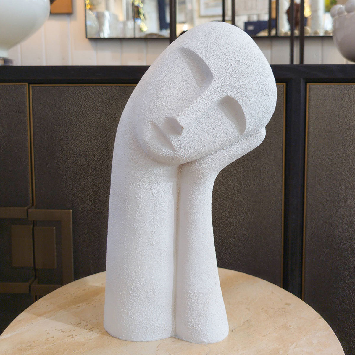 Abstract white sculpture on a round surface with a blurred background