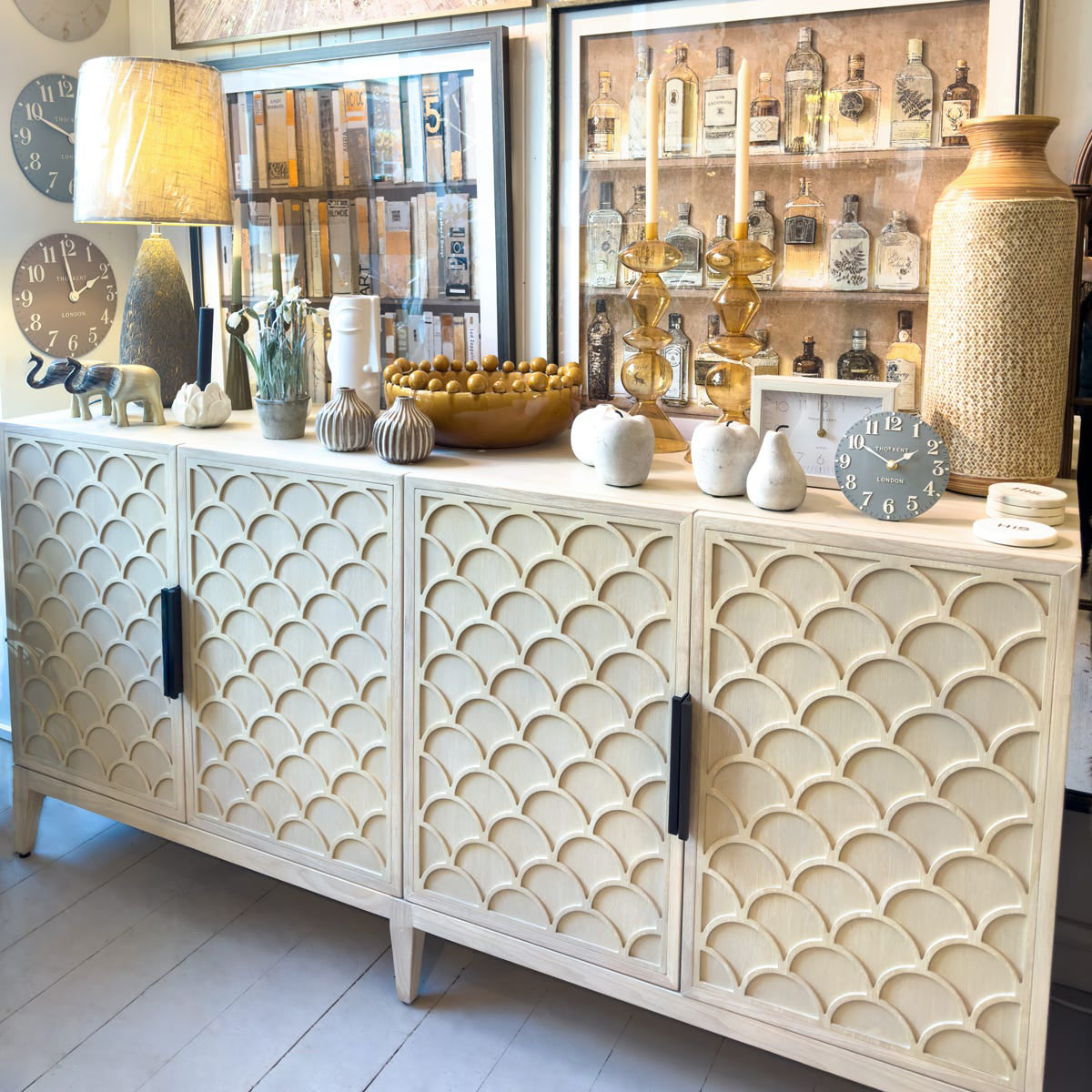 Decorative sideboard with patterned doors and various decorative items on top.