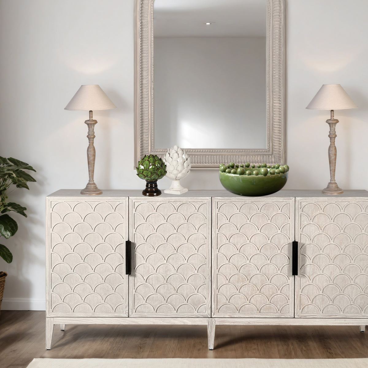 Decorative sideboard with patterned doors, lamps, and a mirror in a room setting.