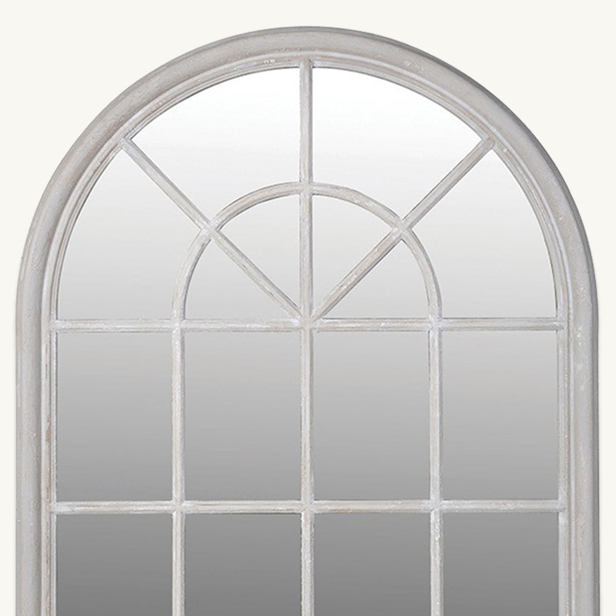 A close up of a grey windowpane mirror with an arched top and distressed frame.