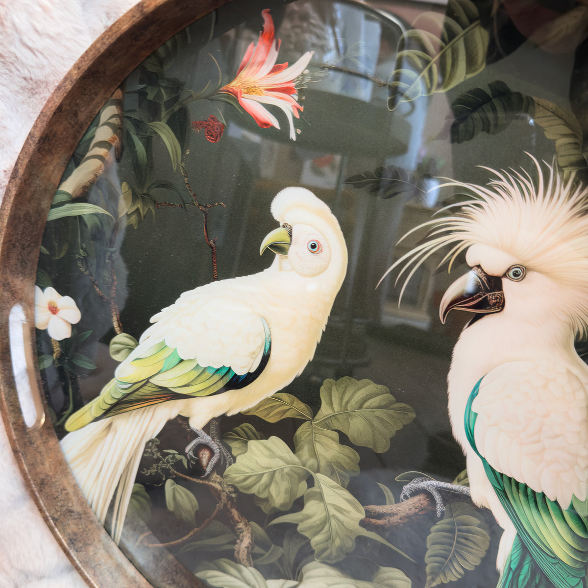 Two cockatiels on a dark green background with a pink flower and green leaves.