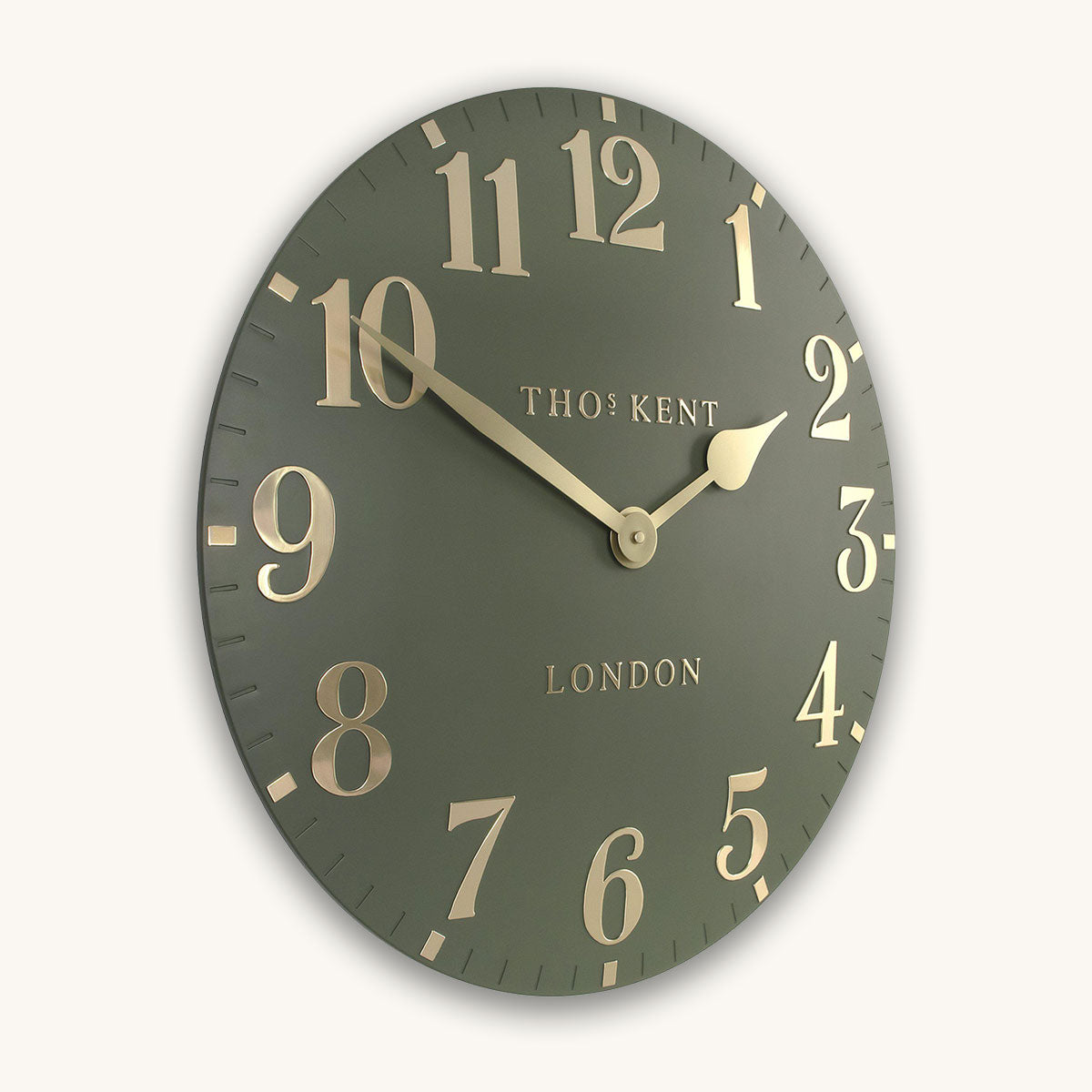 Green wall clock with gold numbers and 'Thomas Kent London' branding on a white background