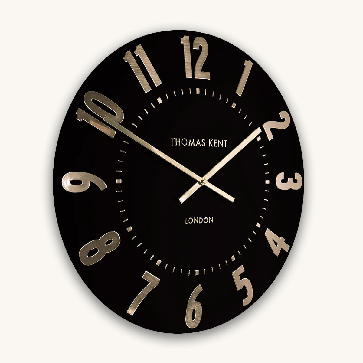 Black wall clock with gold numbers and hands on a white background