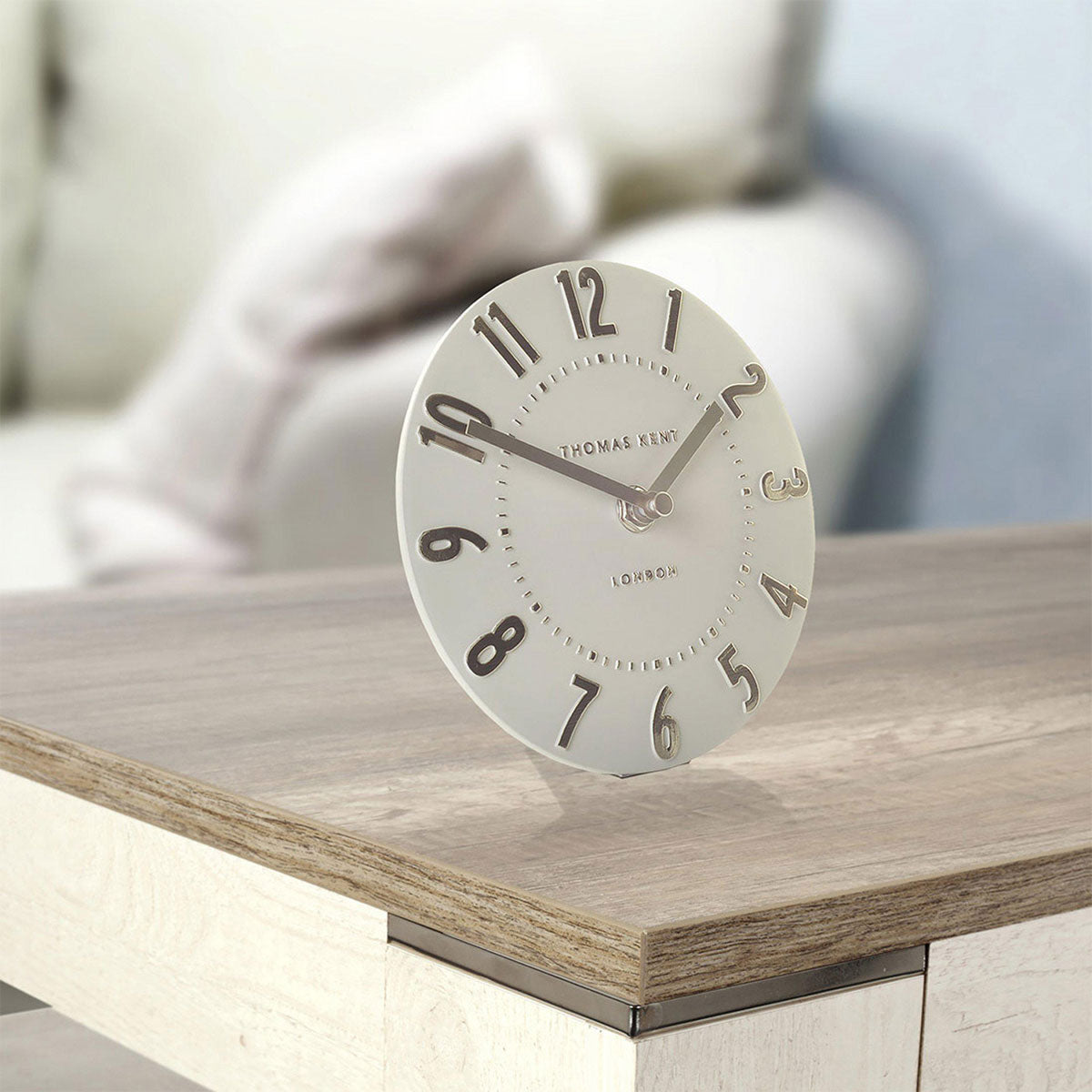 Round clock on a wooden surface with a blurred background