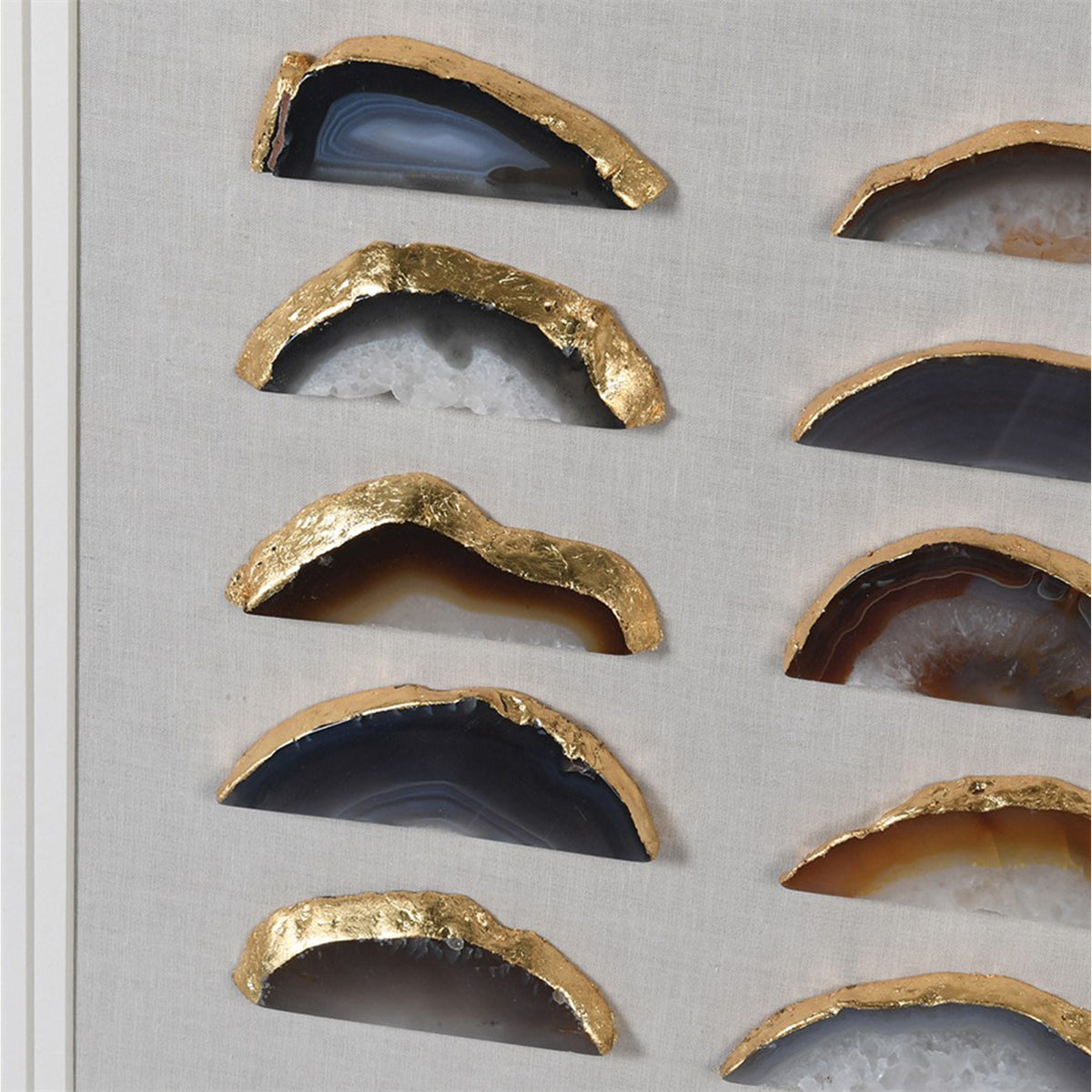 Pieces of agate crystal in earthy tones with gold foil detailing on each piece.