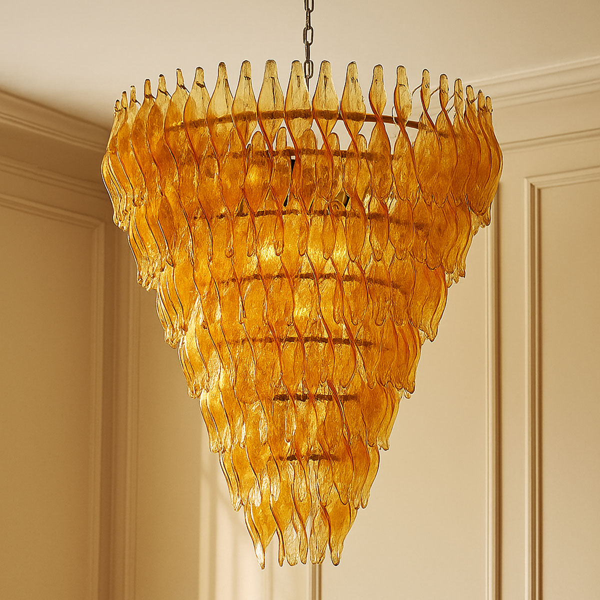 Ornate amber chandelier hanging against a beige wall.