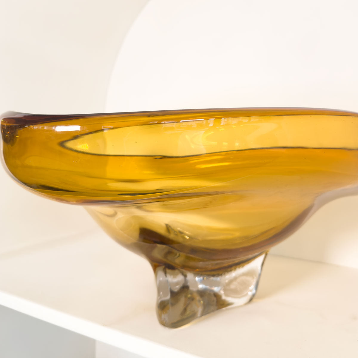 Glass bowl with a warm amber color on a white background