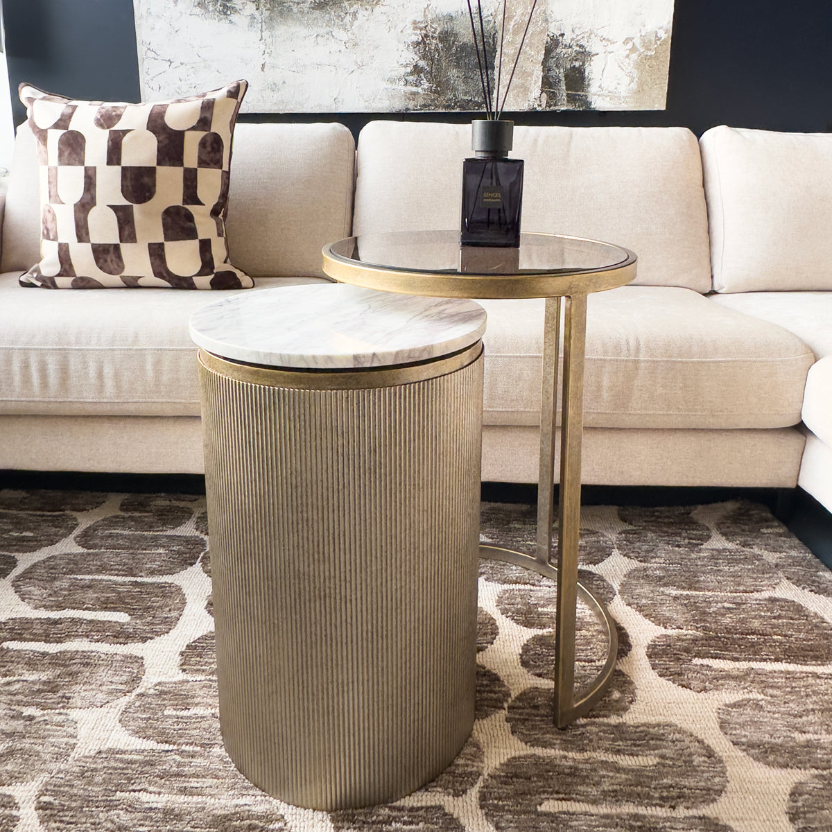 Modern living room with a beige sofa, decorative pillow, and side table.