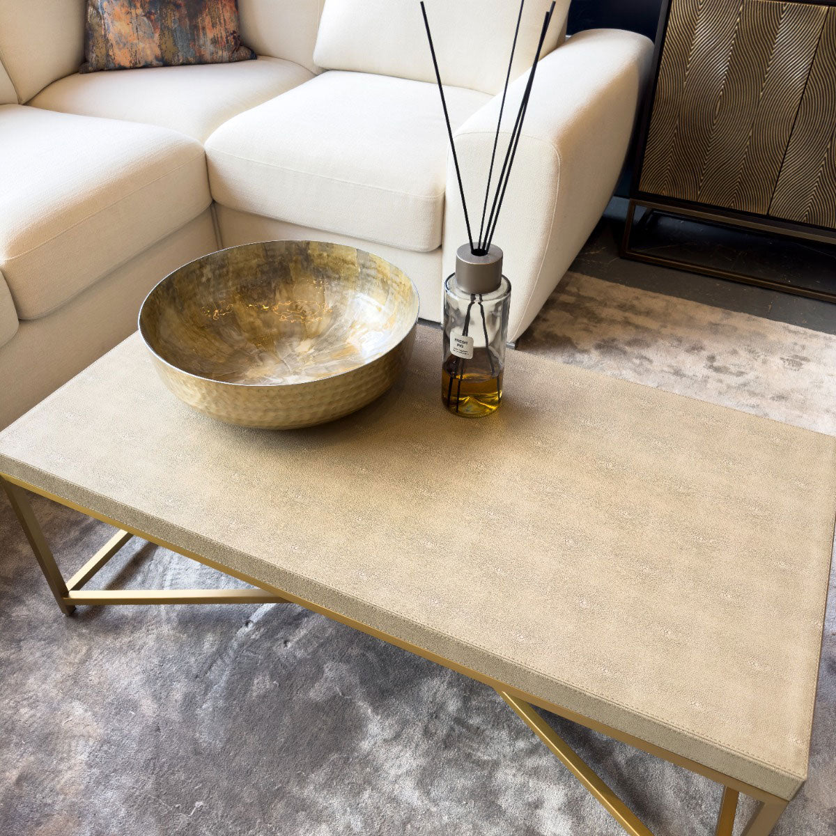 Beige coffee table with decorative items in a living room setting