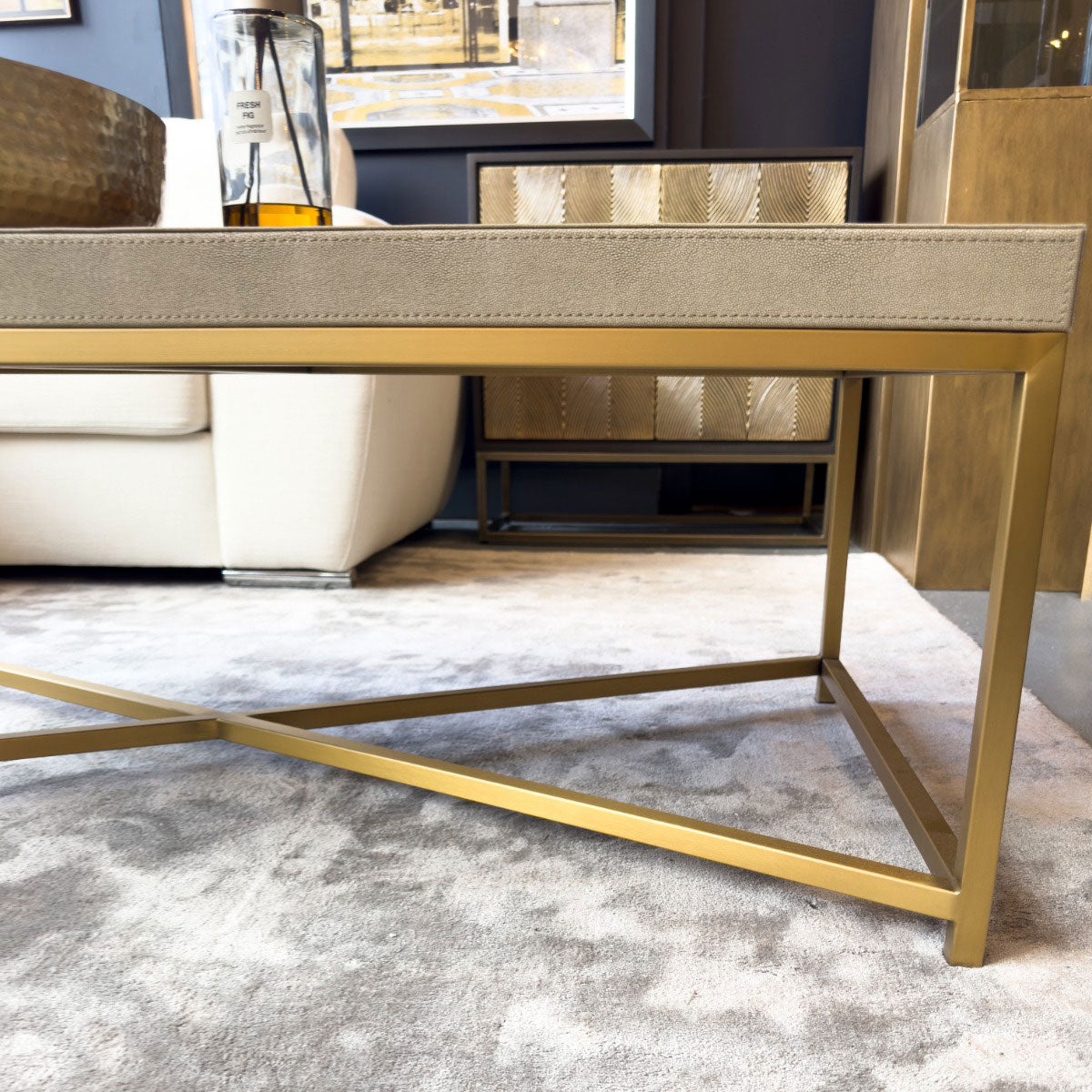 Gold coffee table with a textured shagreen surface in a living room setting