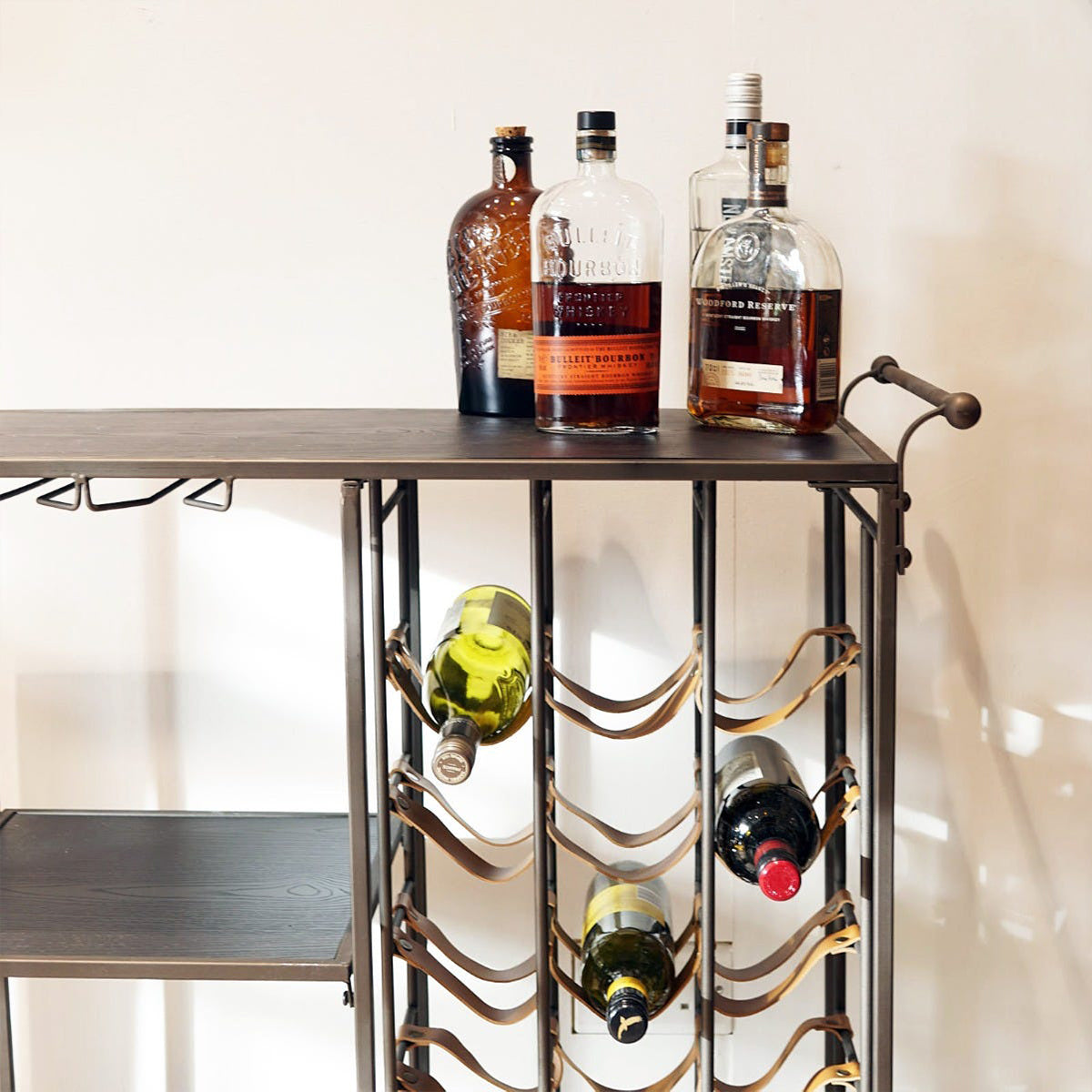 Bar cart with wine bottles and liquor on a white background