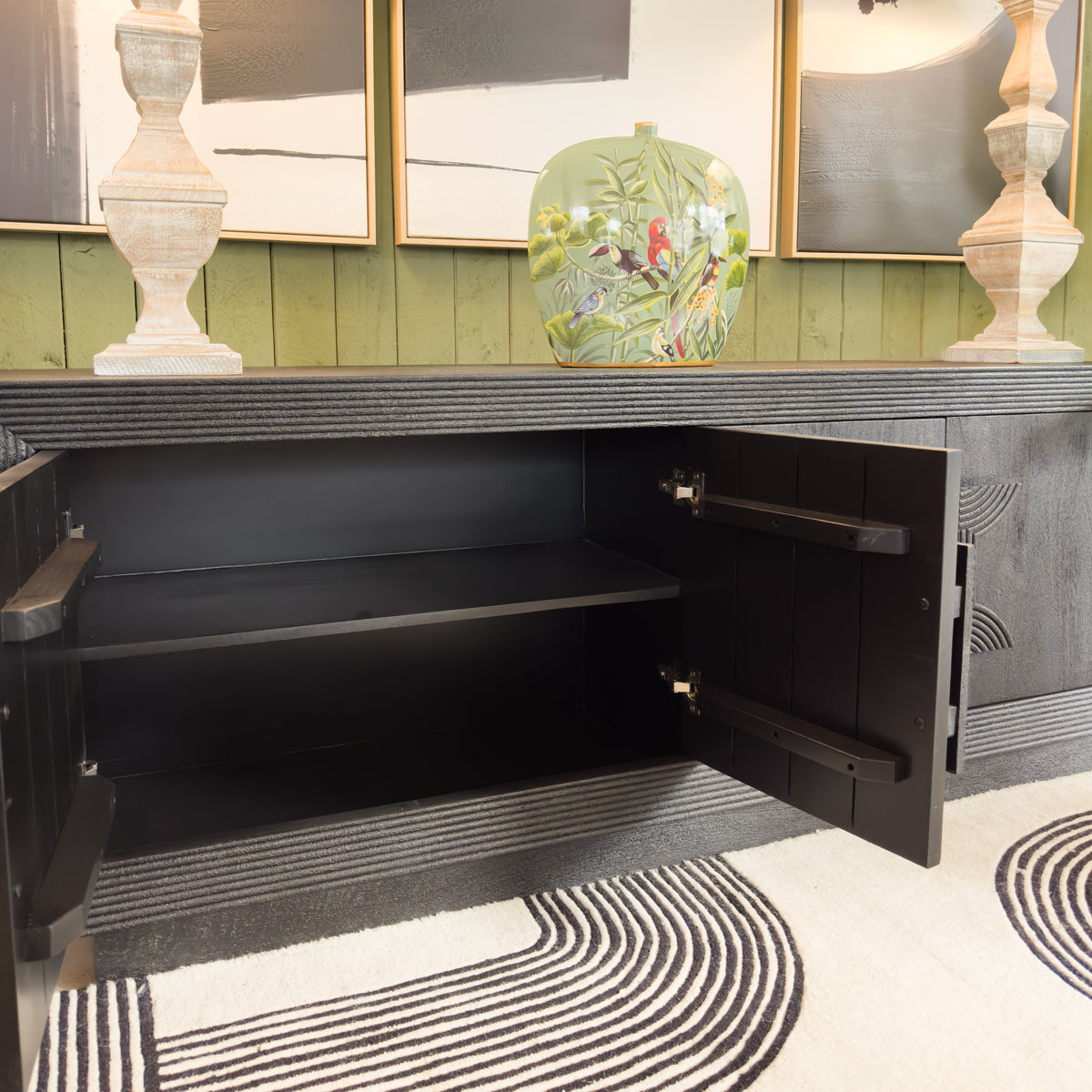Black cabinet with open door in a room with decorative elements.