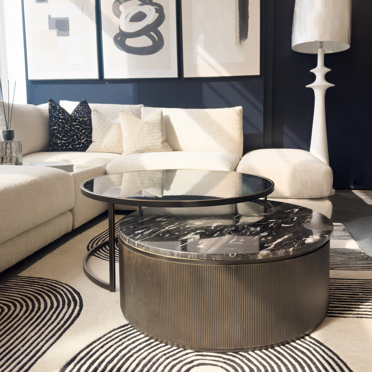 Modern living room with a marble coffee table, sectional sofa, and abstract art on the wall.