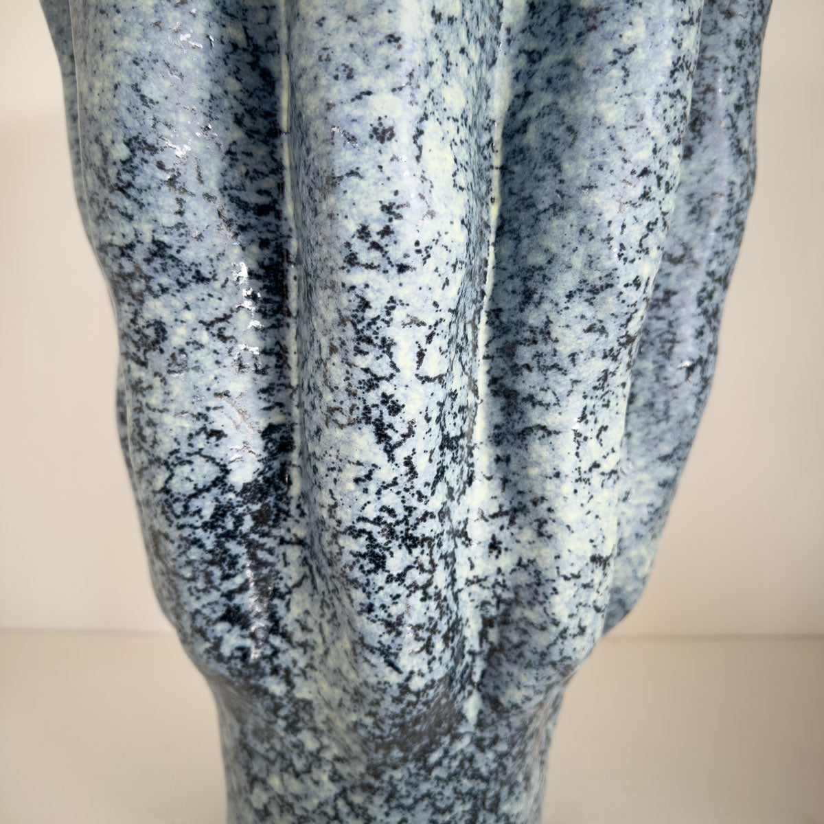Close-up of a textured blue and white vase on a white background